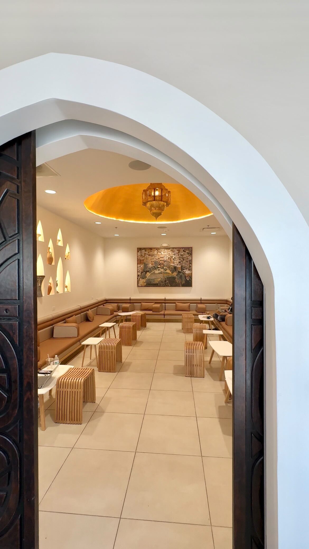 Arwa cafe interior — cream stucco walls with warm pendant lighting.